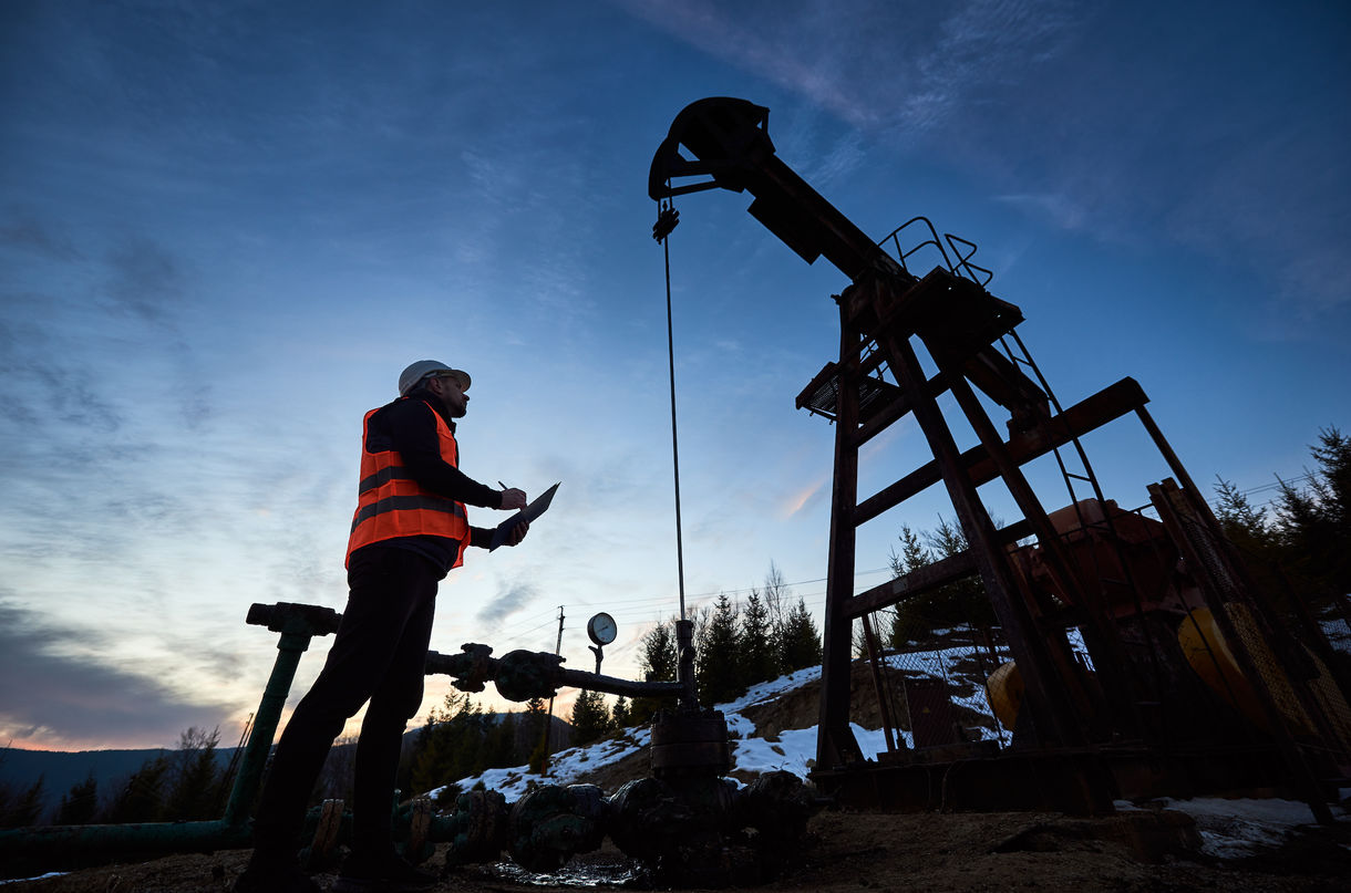 Man looking at oil drill